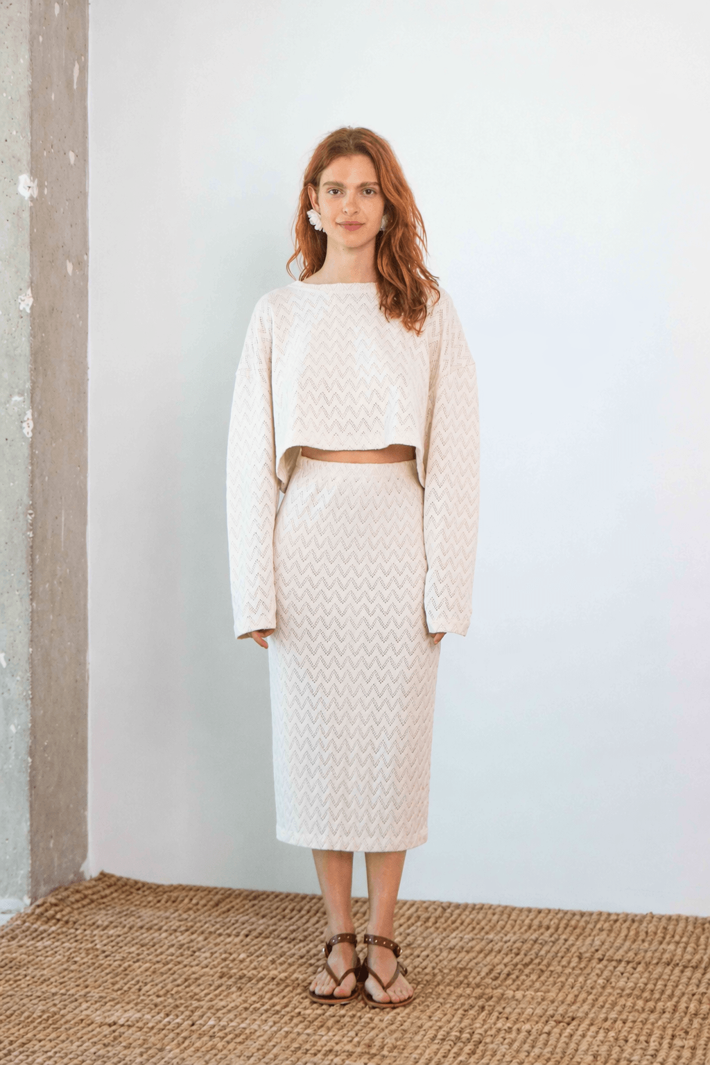 Model wearing a Crochet Organic Cotton Long Sleeve Top styled with a matching midi skirt in ecru color.