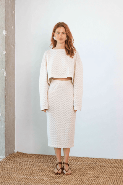 Model wearing a Crochet Organic Cotton Long Sleeve Top styled with a matching midi skirt in ecru color.