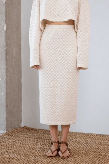 Model wearing a Crochet Organic Cotton Midi Skirt in ecru, showcasing its textured and elegant design.