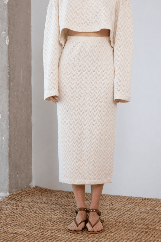 Model wearing a Crochet Organic Cotton Midi Skirt in ecru, showcasing its textured and elegant design.