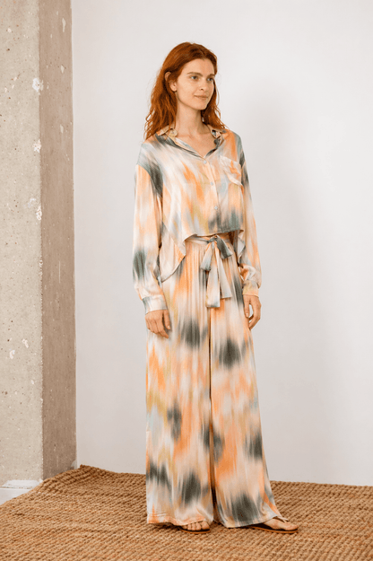 Model wearing Printed Ecovero Viscose Wide-Leg Trousers with a matching shirt in soft colors.