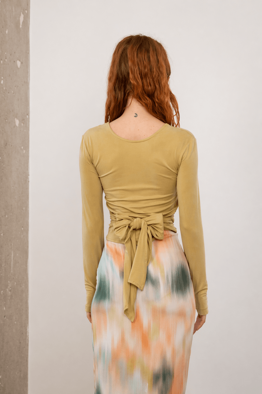 Cupro Multiway Wrap Top in Soft Olive shown from the back, featuring a stylish tie detail.