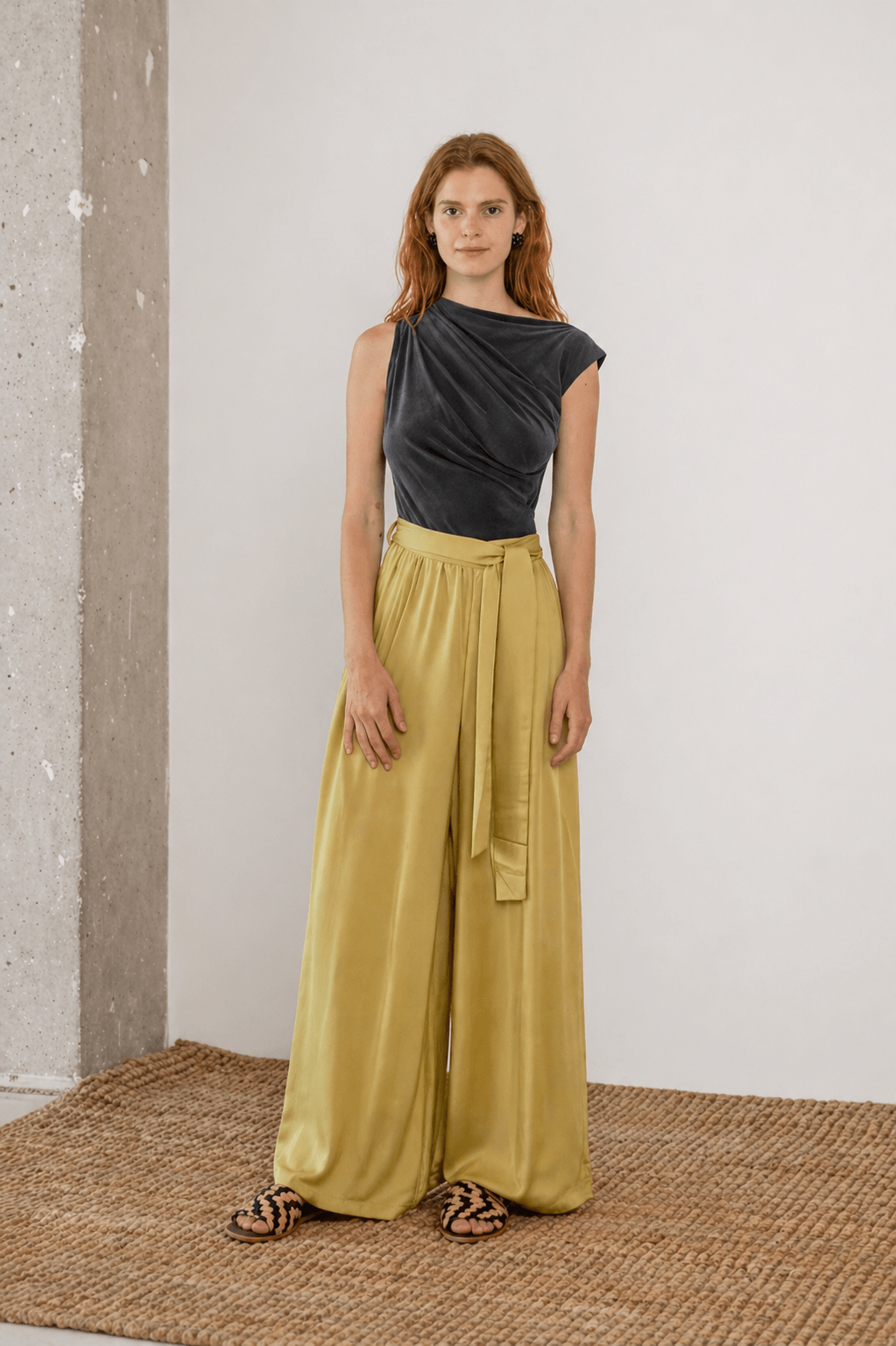 Wide Ecovero Trousers in Soft Olive worn by a model, showcasing their relaxed silhouette and elegant design.
