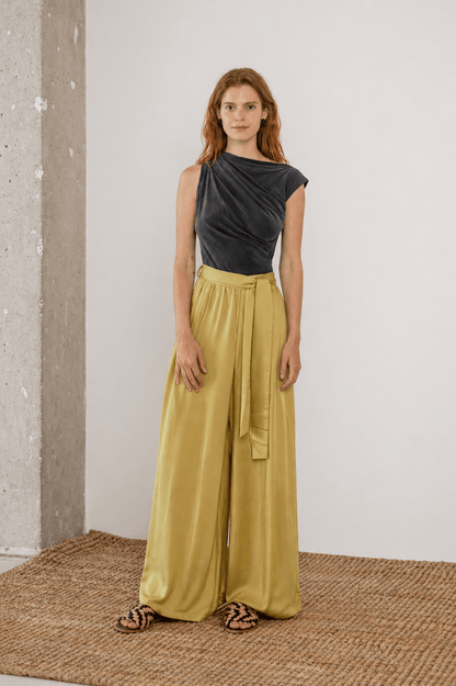 Wide Ecovero Trousers in Soft Olive worn by a model, showcasing their relaxed silhouette and elegant design.