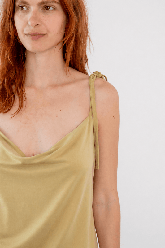 Model wearing the Cupro Drape Slip Top in Soft Olive with adjustable straps and draped neckline.