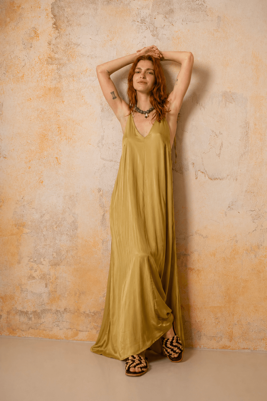 Ecovero Maxi Dress in Soft Olive displayed on a woman, showcasing its fluid silhouette and adjustable straps.