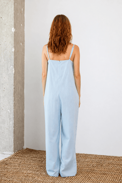 Back view of the Organic Cotton Wide Jumpsuit in Pale Blue, showcasing its relaxed fit and slim straps.