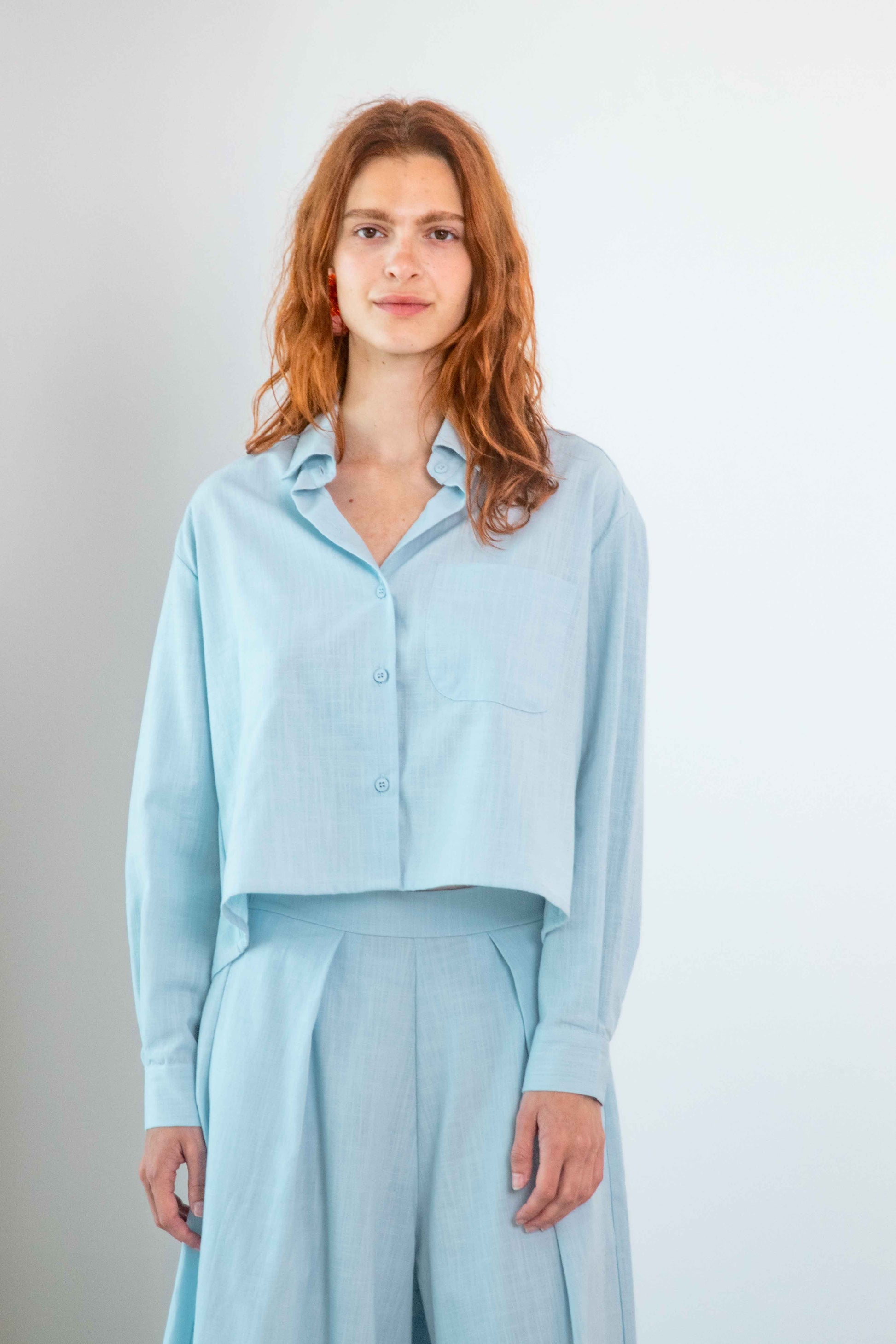 Cropped Organic Cotton Shirt in Pale Blue worn by a model, showcasing relaxed modern styling.