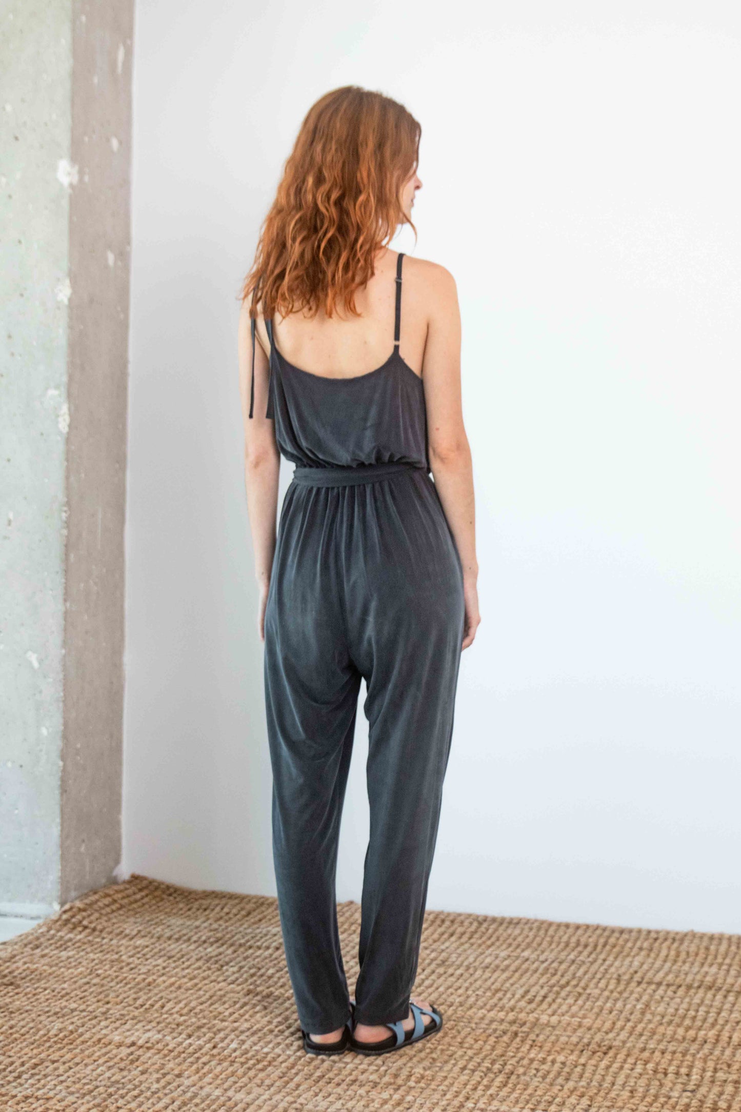 Cupro Slip Jumpsuit with Belt in Slate Black, back view, showcasing its relaxed elegance and flattering fit.