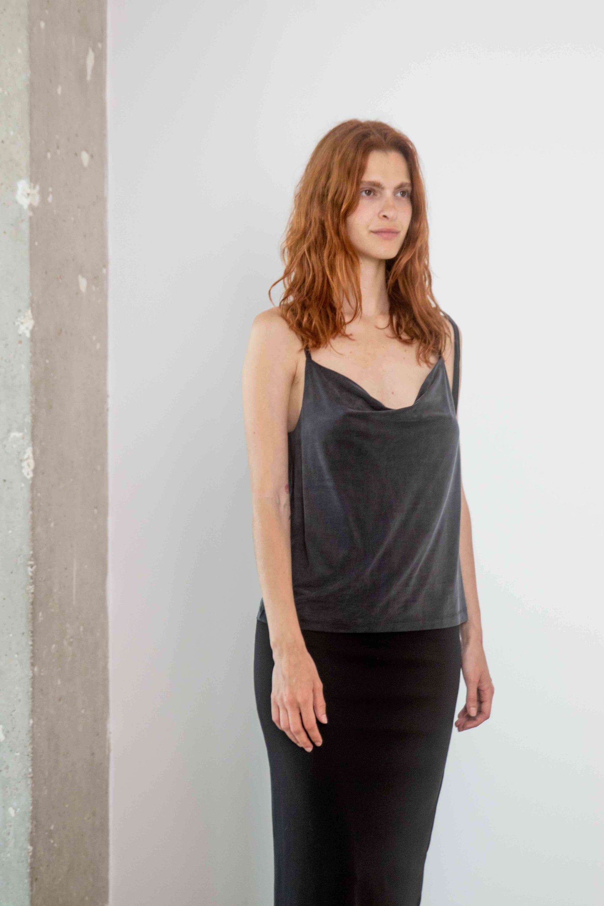 Model wearing the Cupro Drape Slip Top in Slate Black with adjustable straps and flattering draped neckline.