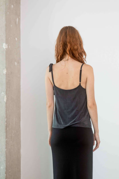 Model wearing the Cupro Drape Slip Top in slate black, showcasing adjustable straps and a fluid silhouette.