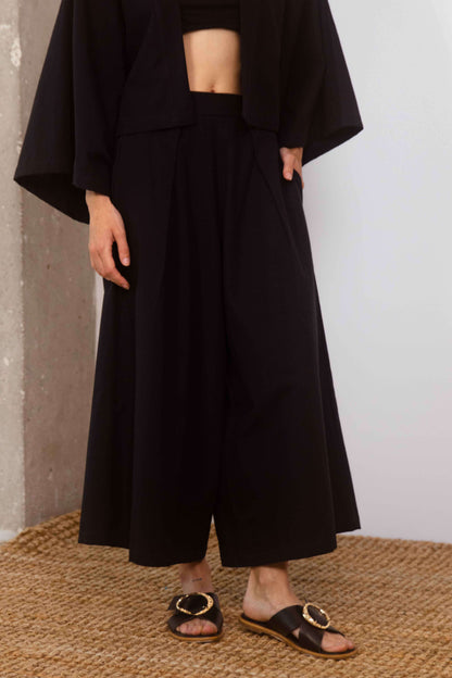 Organic Cotton Wide Culottes in Black, featuring a relaxed silhouette and cropped design, styled with sandals.