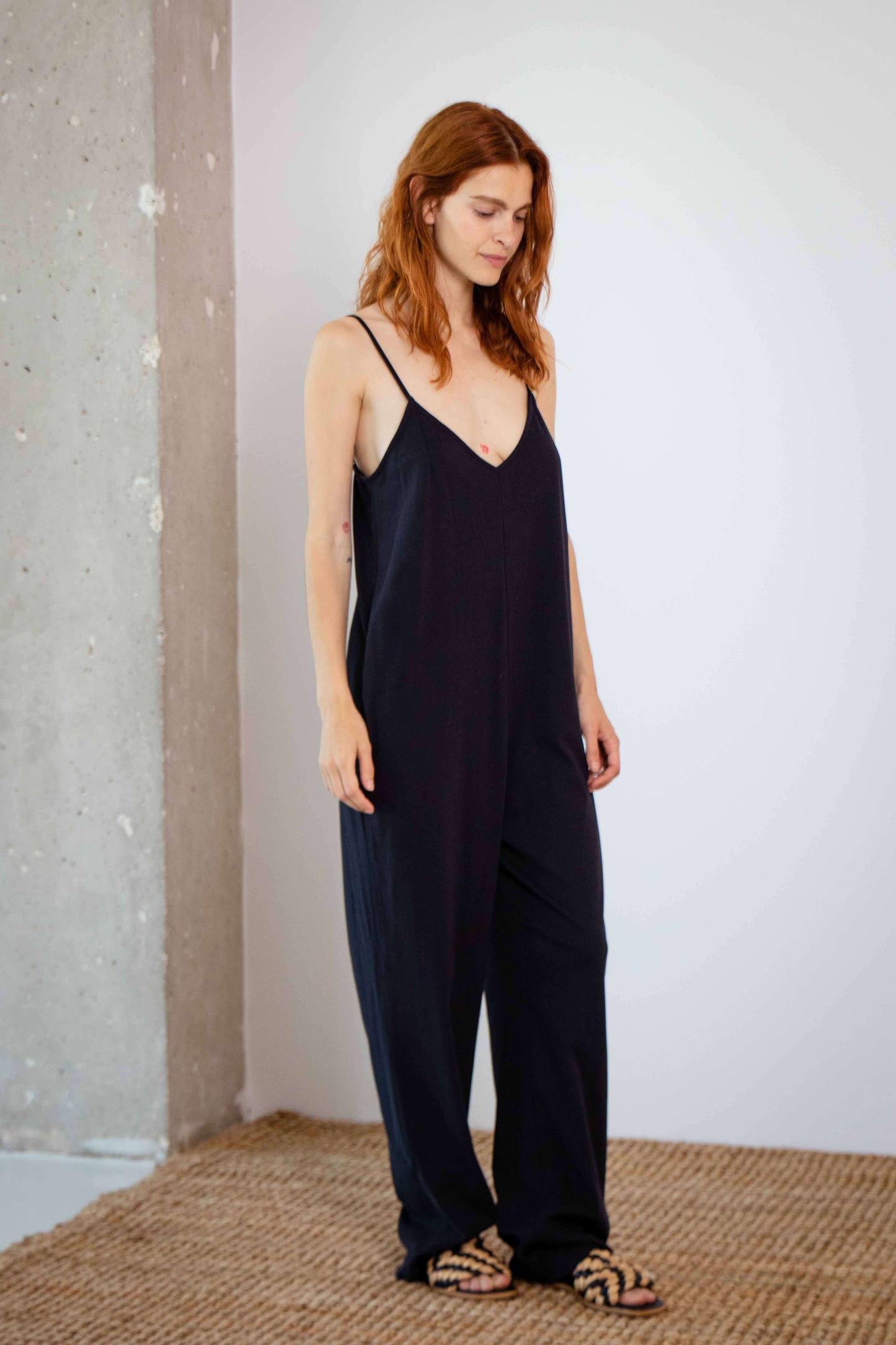 Organic Cotton Wide Jumpsuit in Black worn by a model, showcasing its relaxed fit and elegant design.