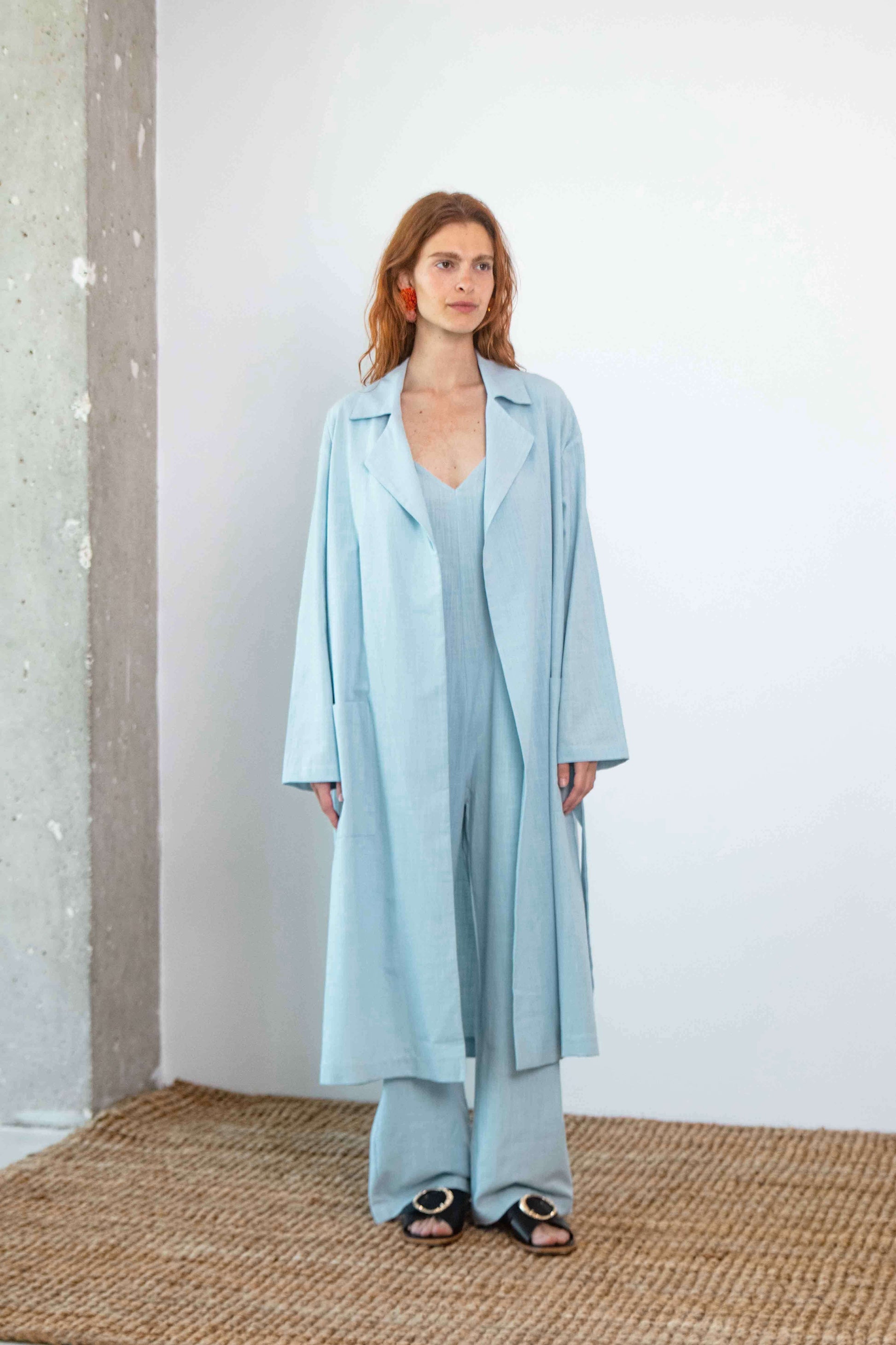 Lightweight Organic Cotton Trench Coat in Pale Blue worn by model with relaxed fit and detachable belt.