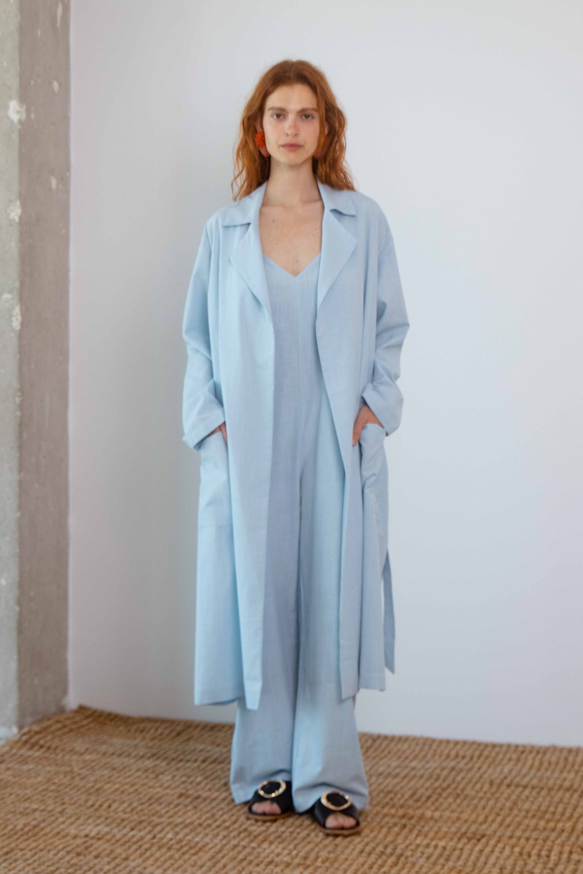 Lightweight Organic Cotton Trench Coat in Pale Blue worn by a model, highlighting its relaxed silhouette and breathable fabric.
