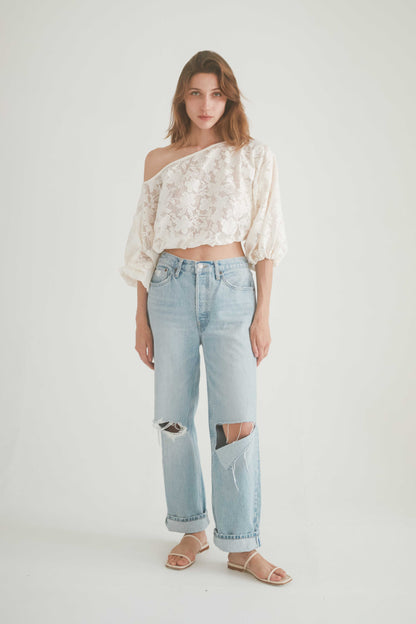 Model wearing a lace boho blouse with balloon sleeves paired with ripped jeans for a chic, effortless look.