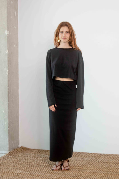 Organic Cotton Midi Skirt in Black worn with a matching black crop top, showcasing a sleek and modern outfit.