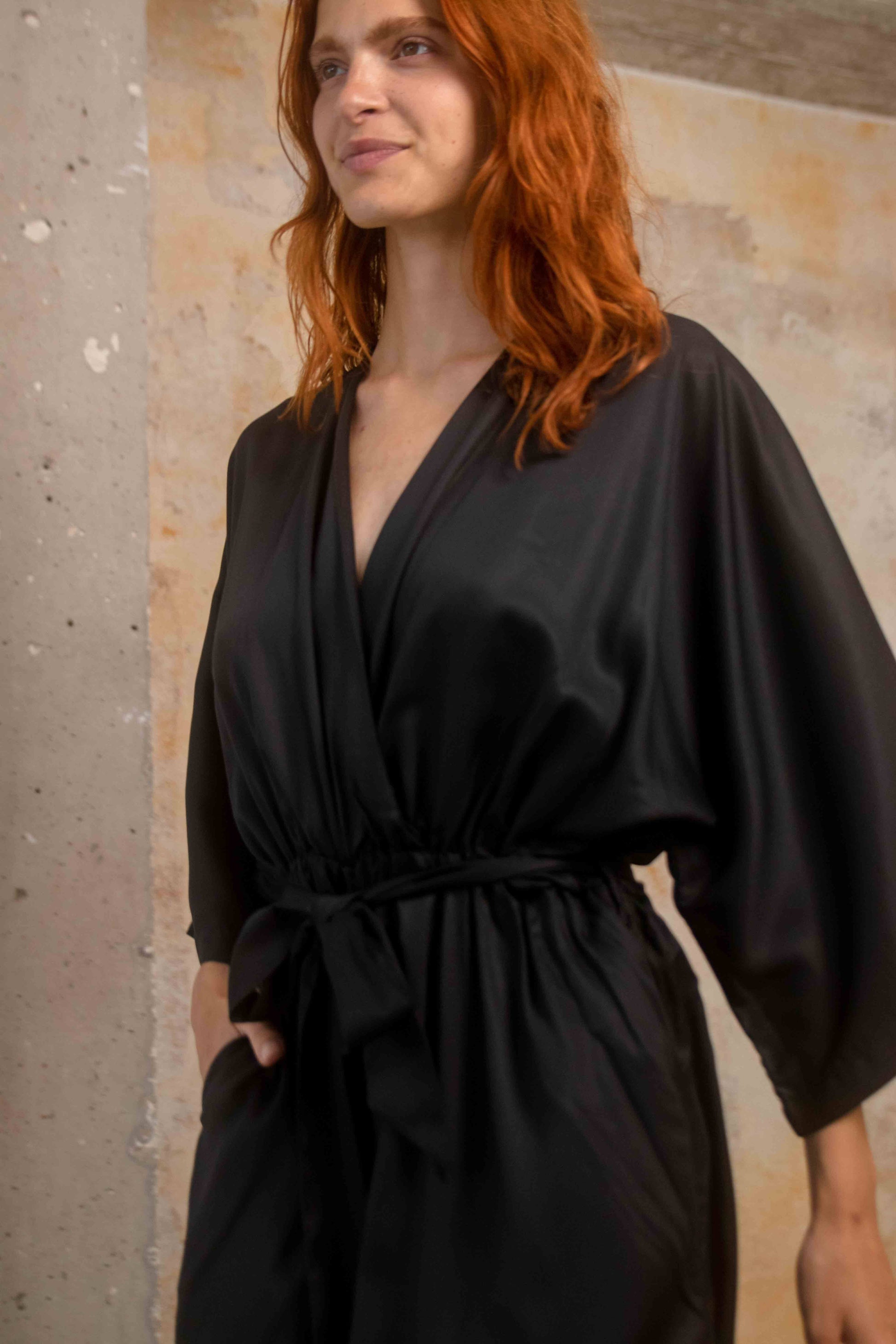 Model wearing Tencel Kimono Jumpsuit in Black, showcasing relaxed silhouette and elegant style.