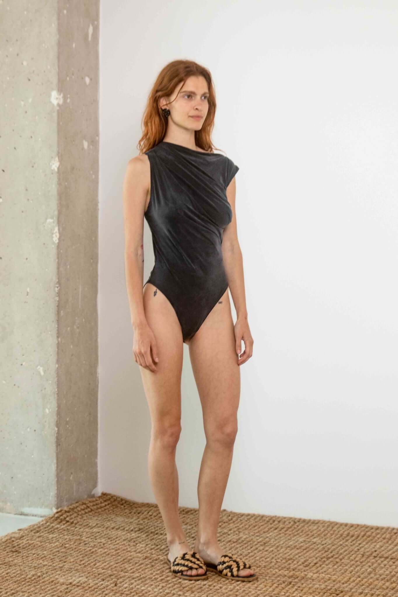 Model wearing Drape Neckline Bodysuit in Slate Black, showcasing its sculpted design and draped detail.