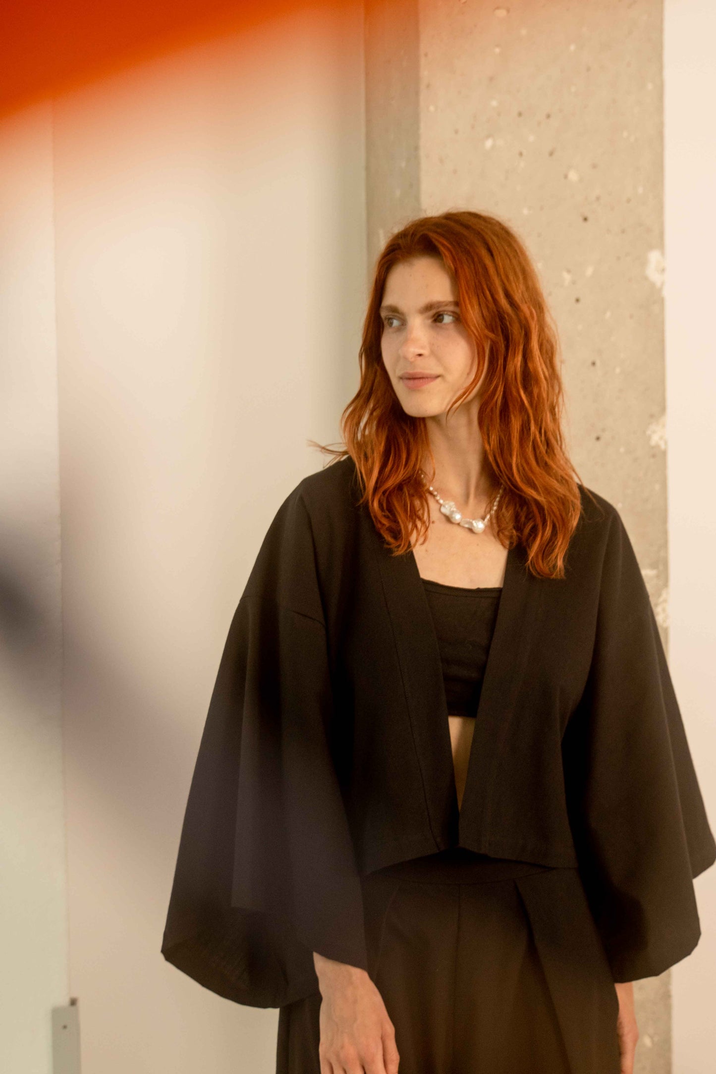 Woman wearing a Organic Cotton Kimono Jacket, showcasing stylish oversized layering for warm weather.