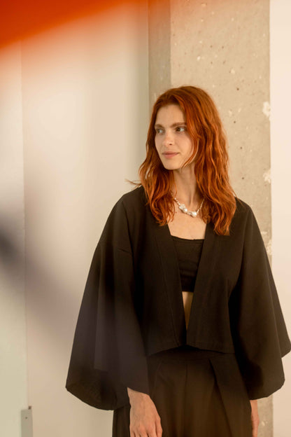 Woman wearing a Organic Cotton Kimono Jacket, showcasing stylish oversized layering for warm weather.