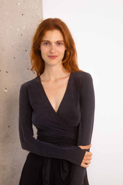 Model wearing a Cupro Multiway Wrap Top  in Slate Black, showcasing its versatile and flattering design.