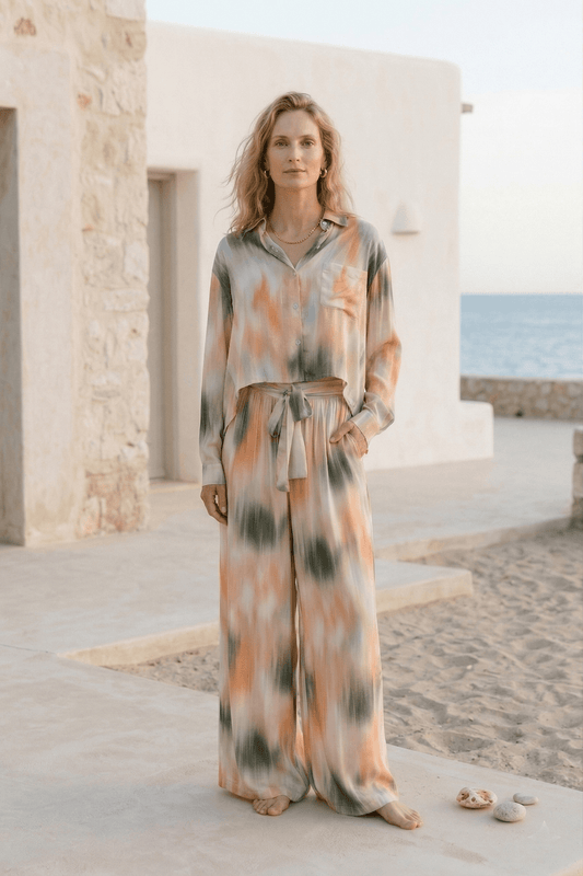 Model wearing Printed Ecovero Viscose Wide-Leg Trousers in a seasonal print by the beach.