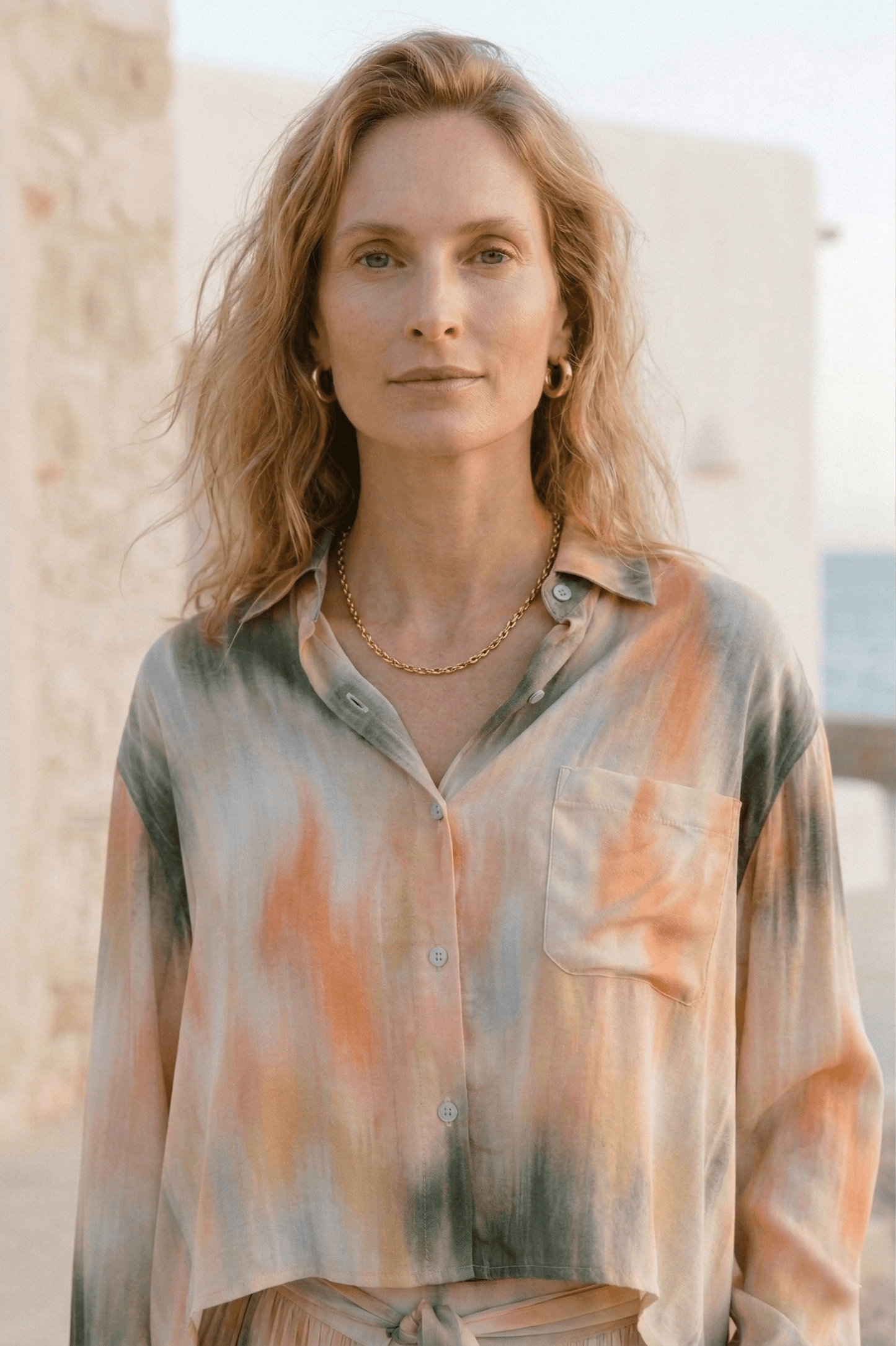 Printed Cropped Ecovero Viscose Oversized Shirt worn by a model with a relaxed hairstyle against a coastal background.