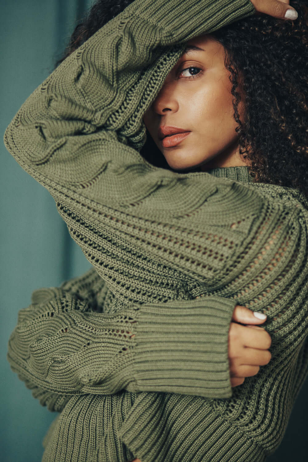 Model wearing sage green wide fit sweater made from 100% organic cotton yarn from Porto, showcasing detailed knit pattern.