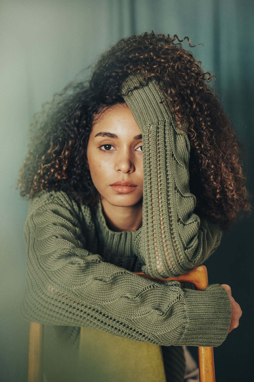 Woman wearing sage green sweater made from organic cotton yarn from Porto, Portugal, displaying crop and wide fit.