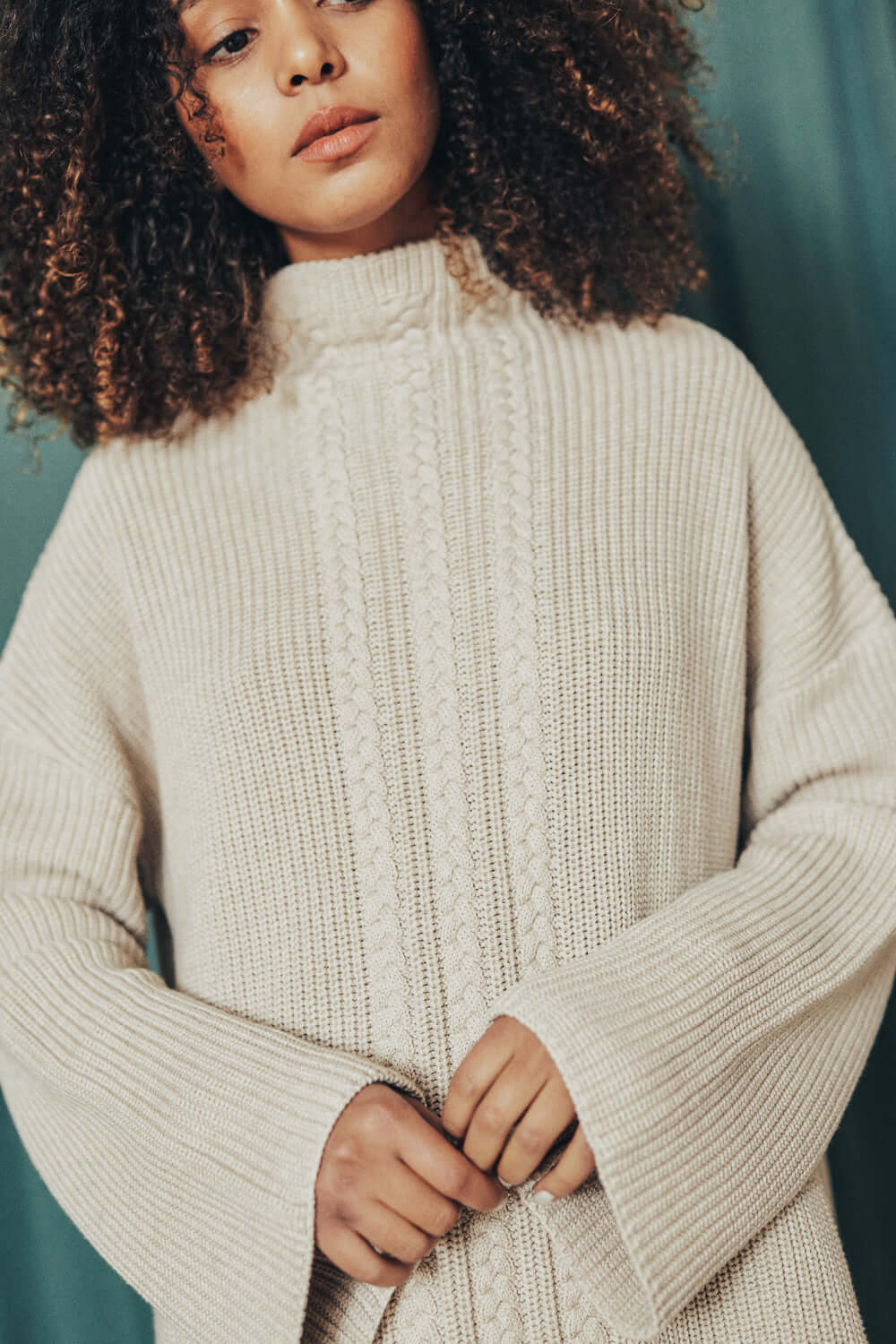 Model wearing oat tunic sweater made from 100% organic cotton yarn, in oatly beige color, size M