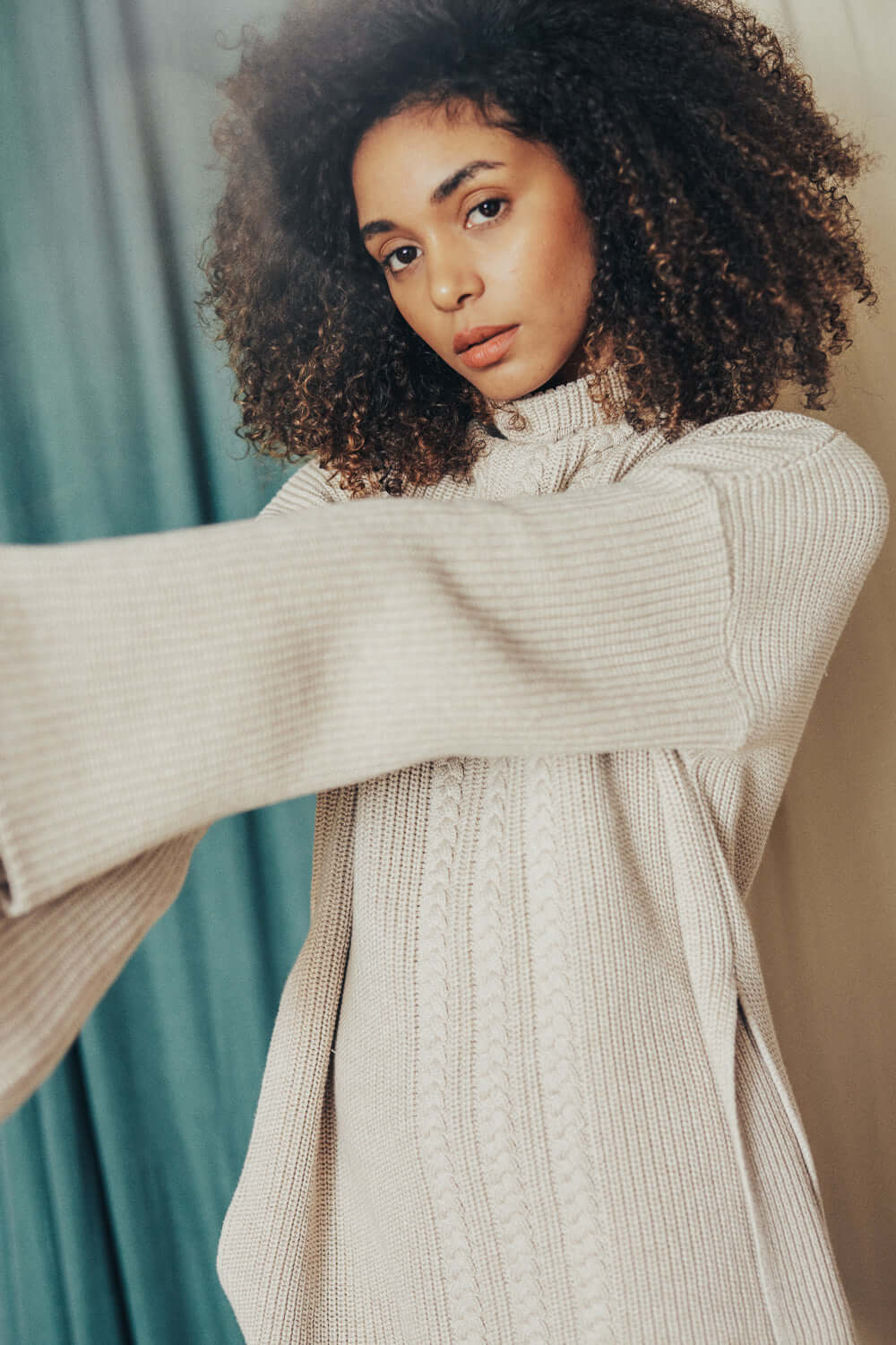 Woman wearing an OAT TUNIC SWEATER made of 100% organic cotton yarn in oatly beige color.