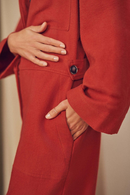 Woman wearing a rust colour boiler suit.