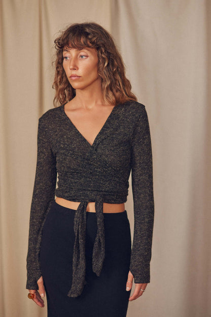 Model wearing khaki multiway recycled jersey wrap top with long sleeves and tie detail, showcasing sustainable fashion.