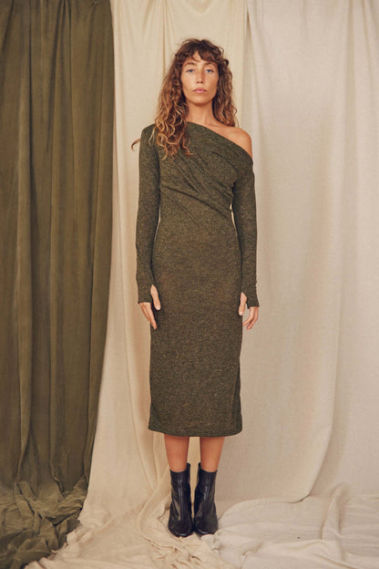 Model wearing a khaki recycled jersey drape dress with an off-shoulder design and thumb holes, set against a neutral backdrop.