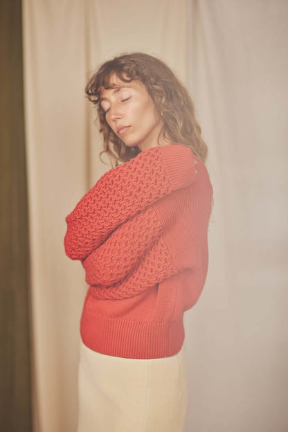 Model wearing a Heavy Knit Rust Vegan Sweater with a unique fantasy sleeve, showcasing the sustainable fashion piece.