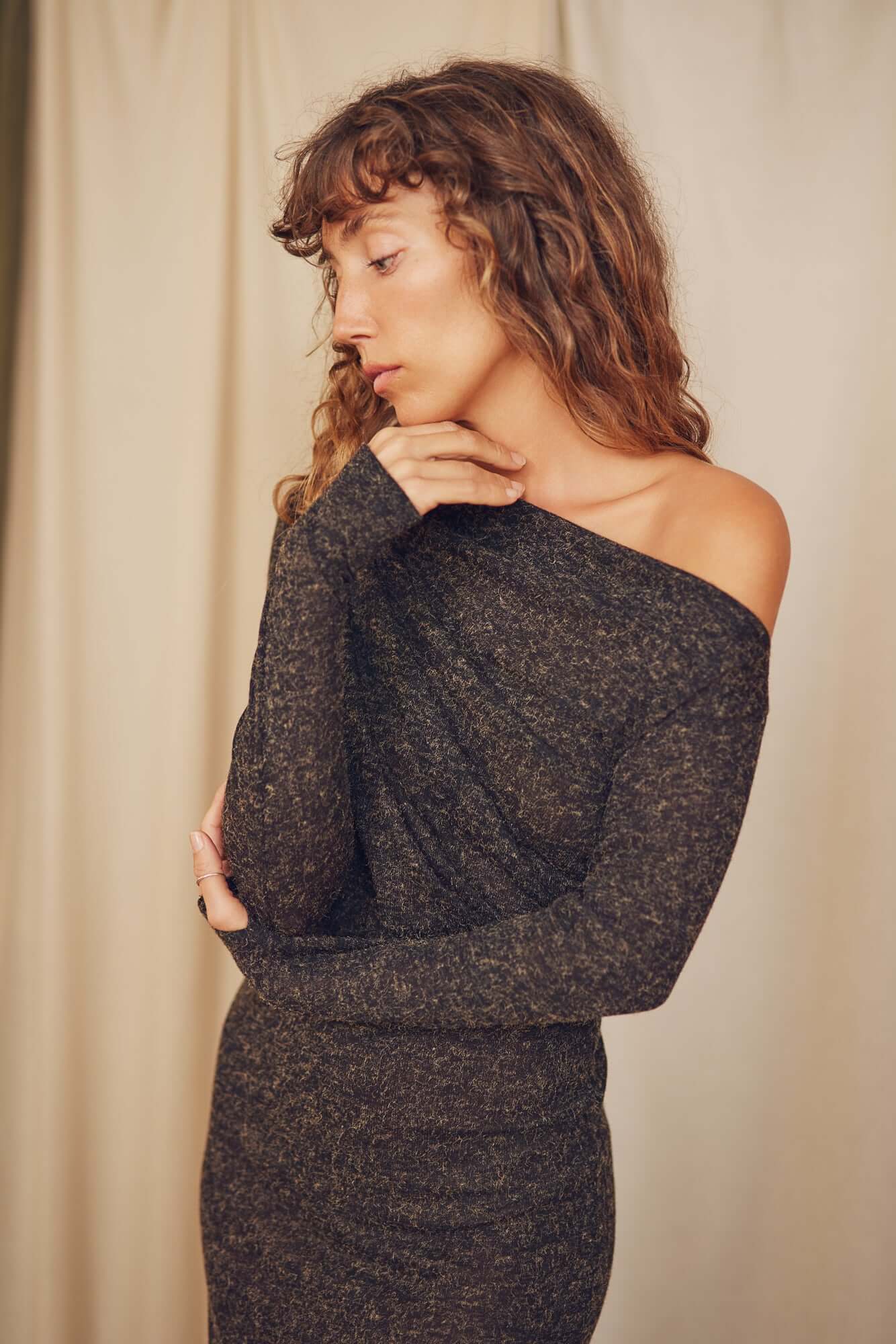 Woman in black recycled jersey drape dress, showcasing flattering neckline and stylish design.