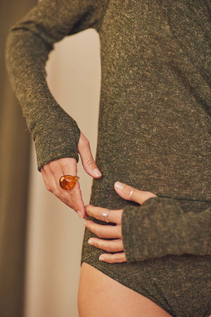 Model wearing khaki recycled jersey drape bodysuit with long sleeves and thumb holes, showcasing autumn style.