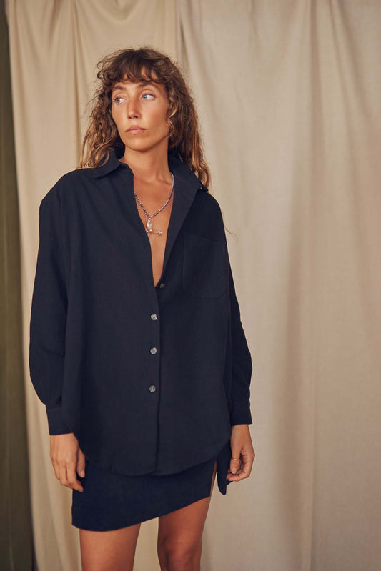 Model wearing a black organic cotton wide overshirt, styled casually, perfect for autumn layering.