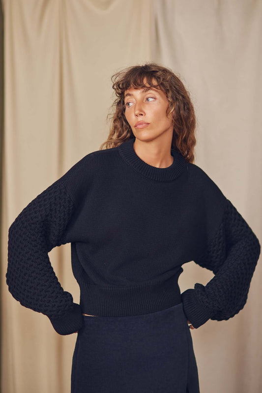 Model wearing a Heavy Knit Black Vegan Sweater with elegant fantasy sleeves and relaxed fit.