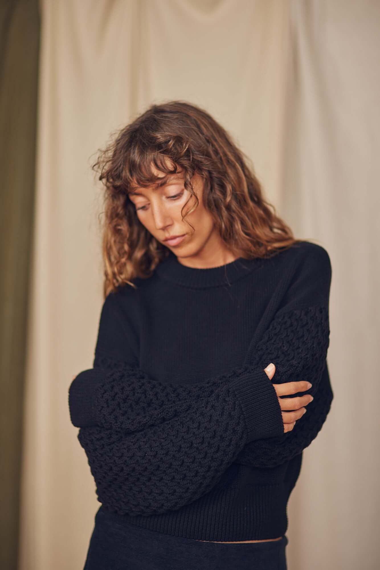 Model wearing a Heavy Knit Black Vegan Sweater featuring elegant fantasy sleeves and a relaxed fit.