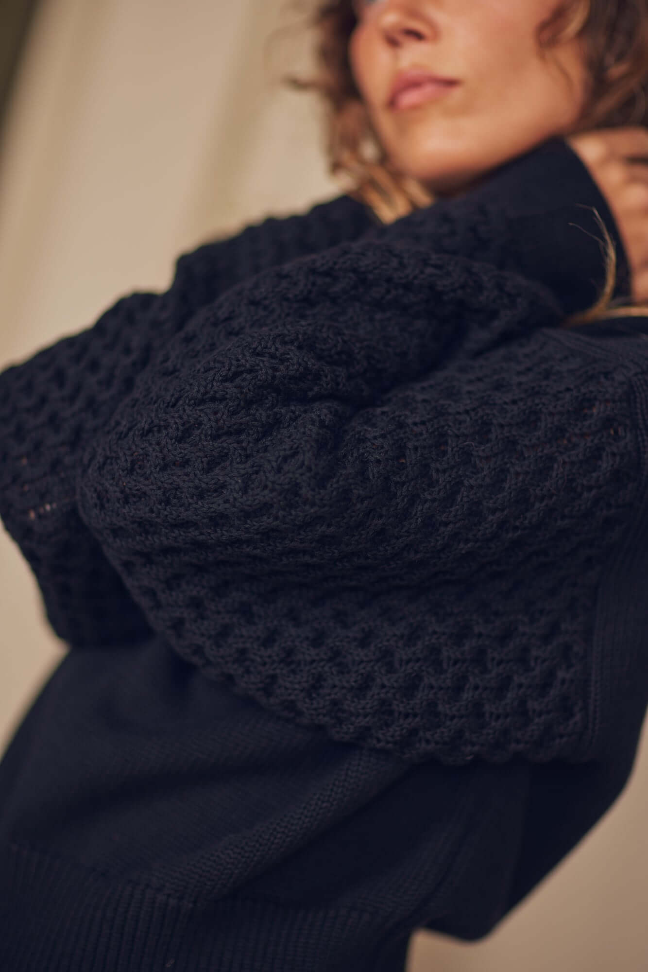 Close-up of a model wearing a Heavy Knit Black Vegan Sweater with elegant fantasy sleeves.