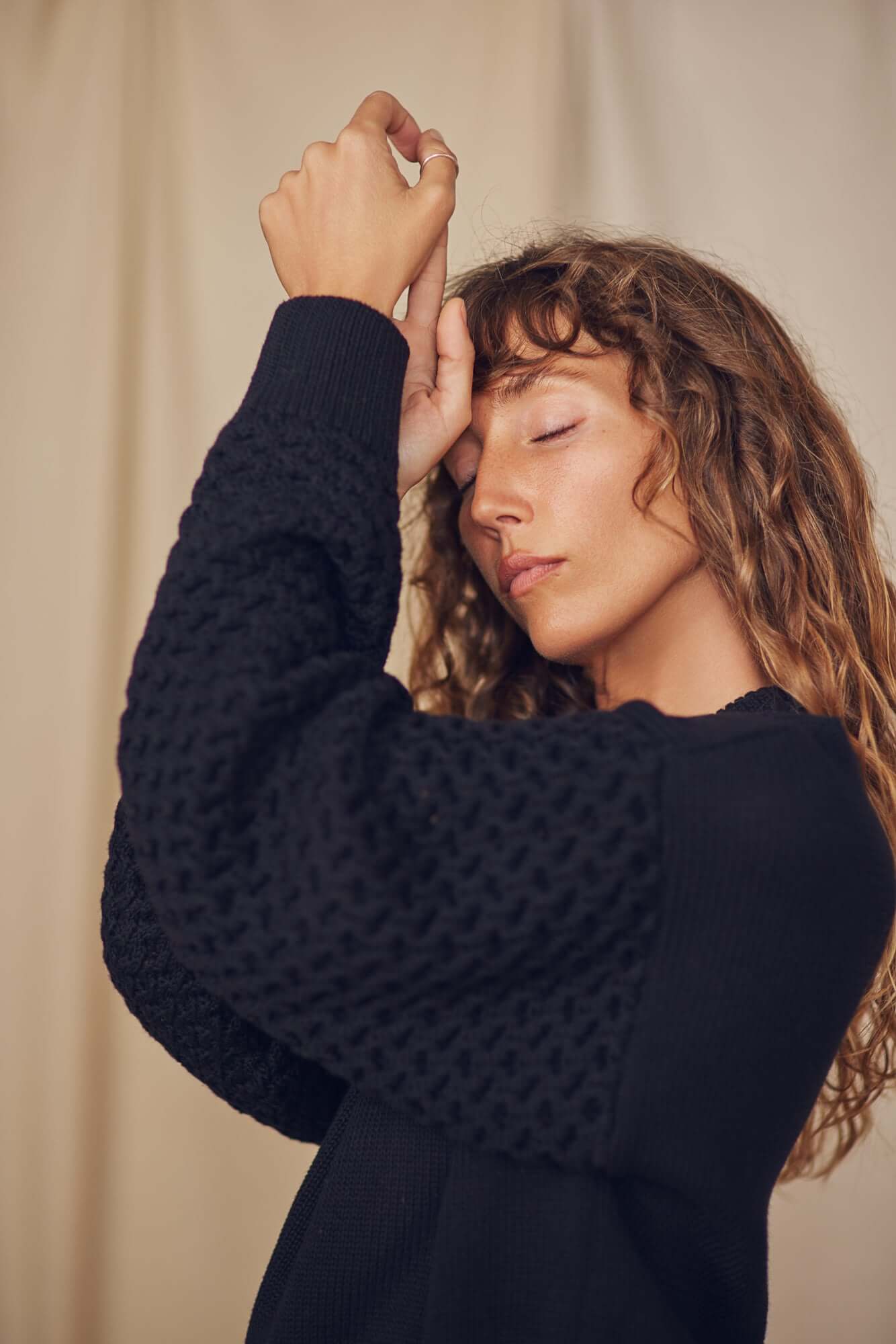 Model wearing a Heavy Knit Black Vegan Sweater, showcasing its unique fantasy sleeves and relaxed fit.