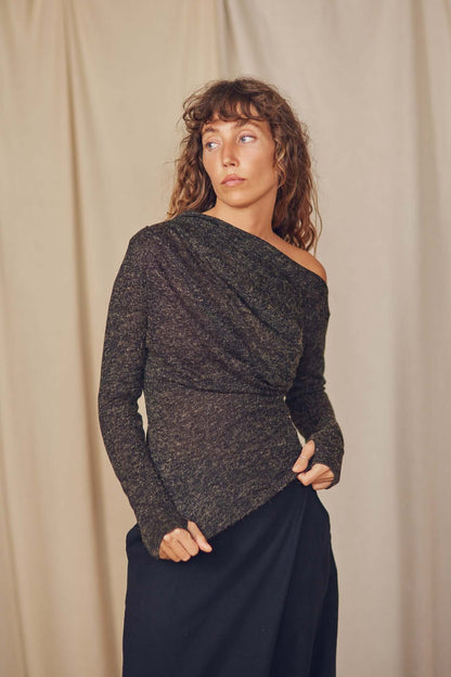 Model wearing a black recycled jersey drape top with a stylish neckline and thumb holes, perfect for autumn layering.