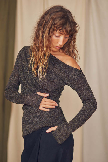 Model wearing a black recycled jersey drape top with chic draped neckline and thumb holes, styled for autumn layering.