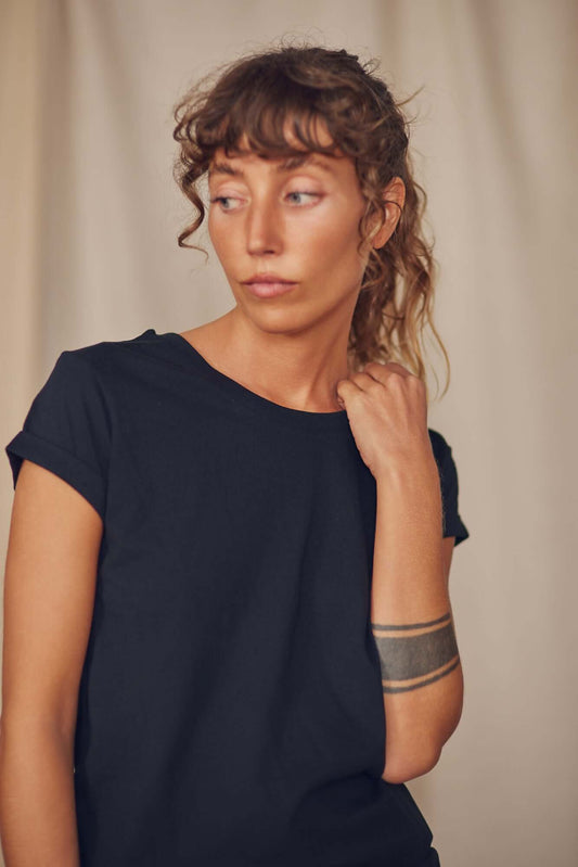 Woman wearing a short sleeve black classic tee made from 100% organic cotton jersey, featuring a relaxed fit.