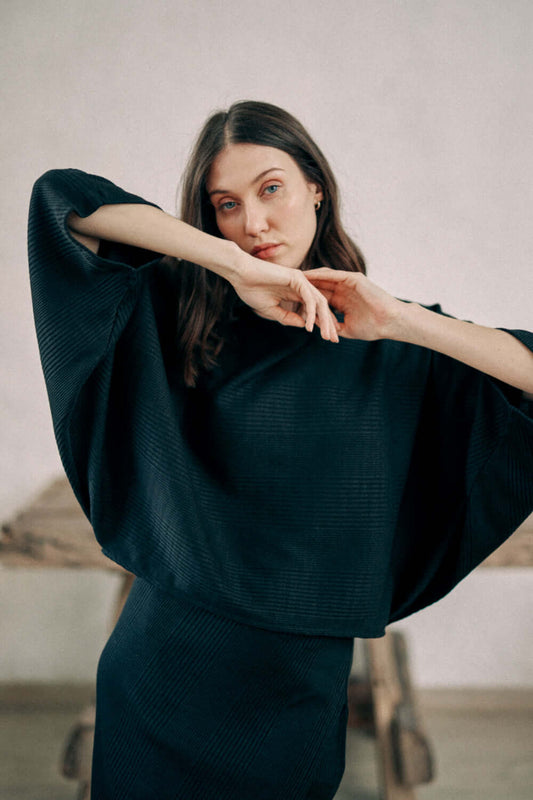 Model wearing black batwing top made of recycled polyester and organic cotton thick jersey fabric from Porto