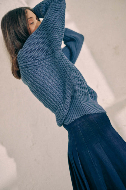 Woman modeling navy sweater made of vegan organic cotton, exclusive online fashion, stylish and eco-friendly knitwear.