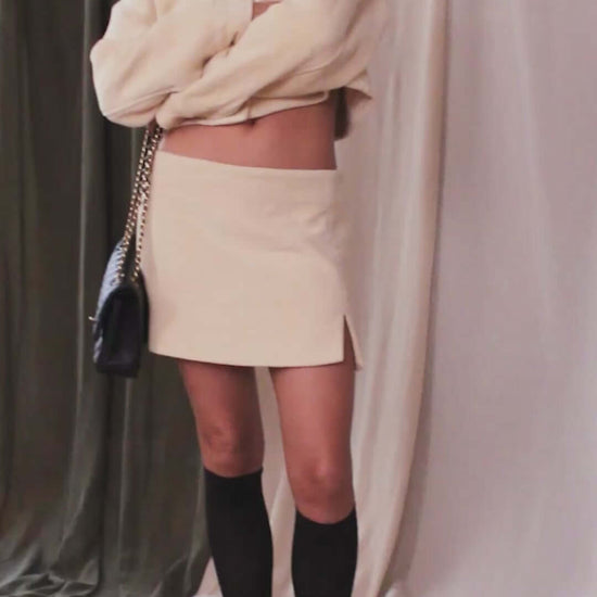Model wearing an Oat Organic Cotton Crop Jacket with a matching skirt and knee-high socks, showcasing sustainable fashion style.