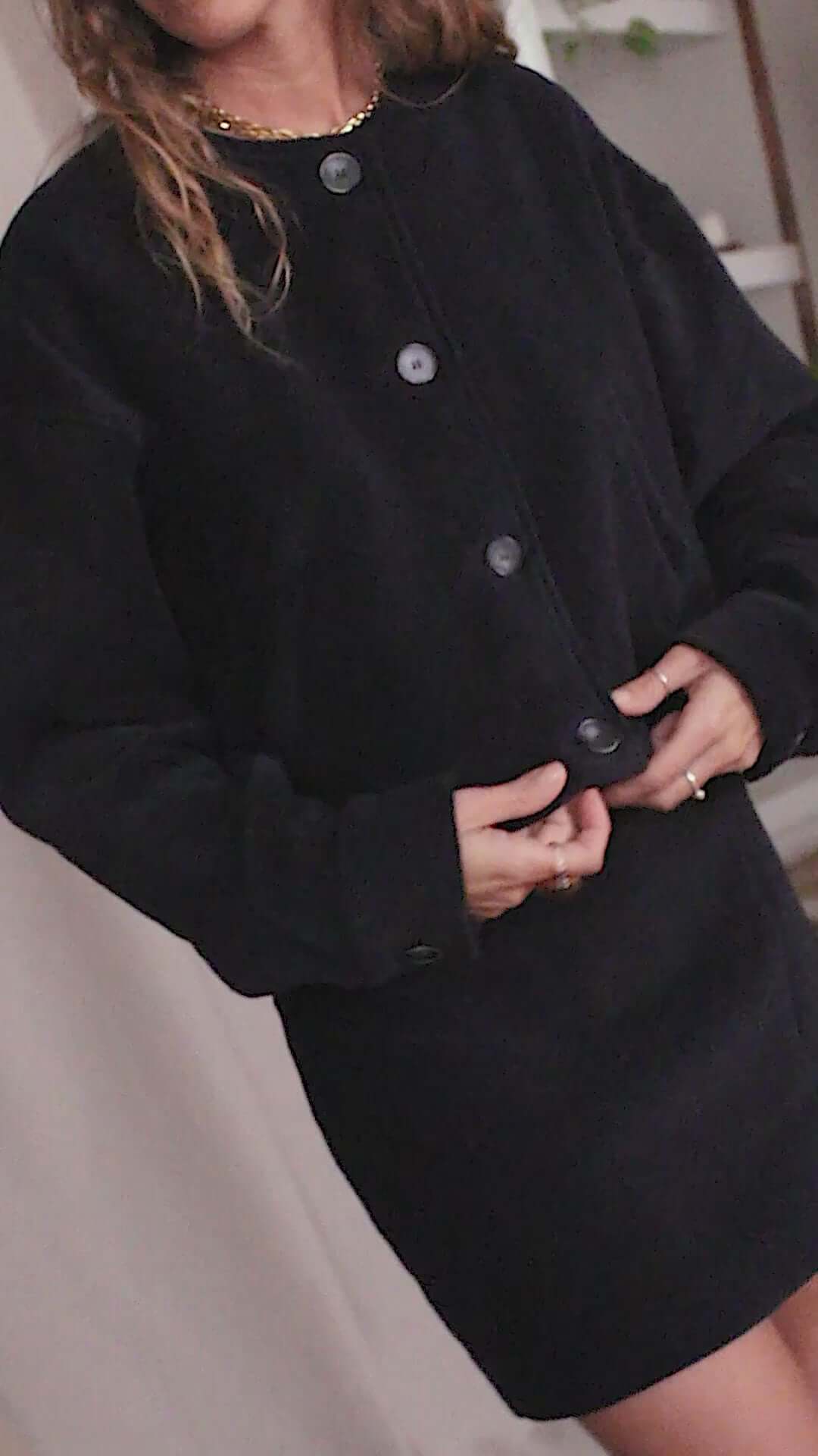 Model wearing a black organic cotton crop jacket with eco buttons, showcasing a stylish bomber-inspired design.